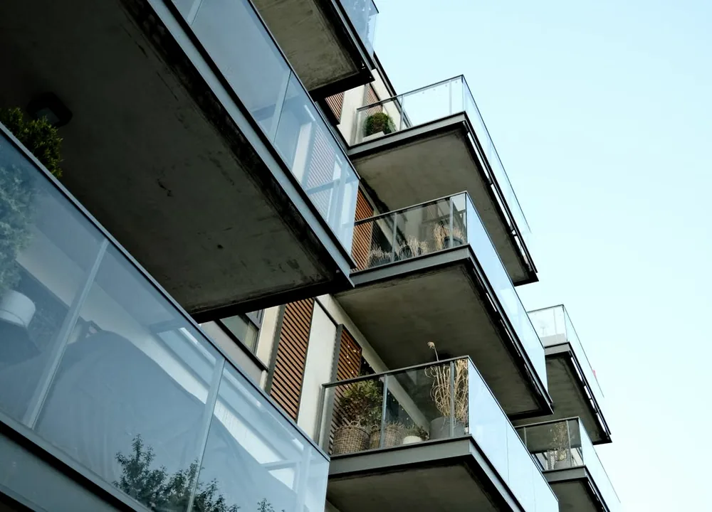 Fachada contemporânea com guarda-corpos de vidro